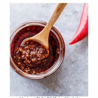 small bowl of chile oil (salsa macha) with tip of red pepper showing.