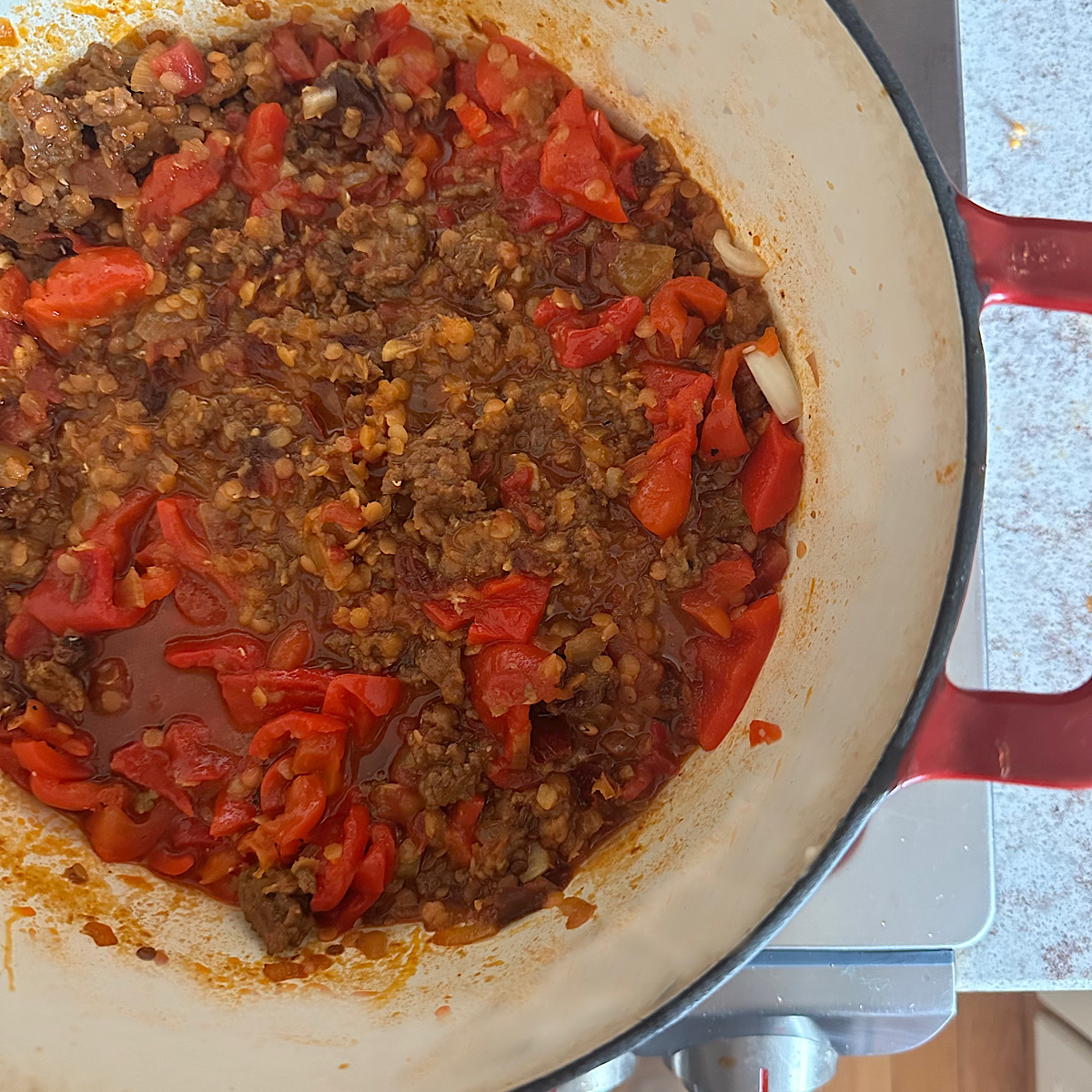 Chorizo lentil stew cooking on stovetop.