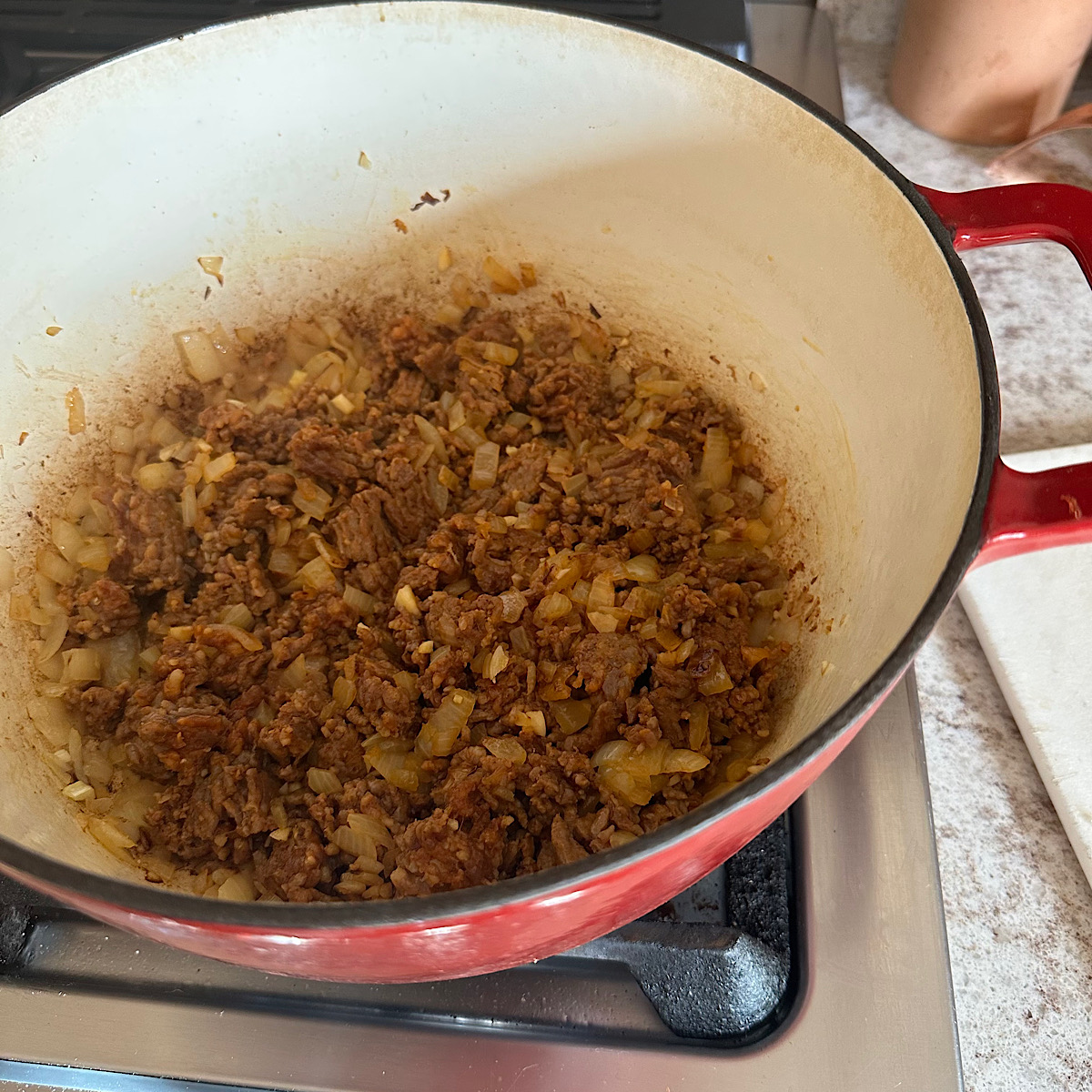 Chorizo and onions cooking in dutch oven.