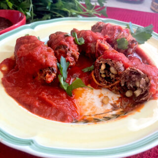 Plate of beef braciole smothered in tomato sauce.