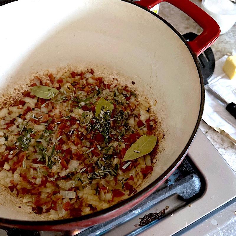 Bacon, onions and spices cooking in dutch oven.