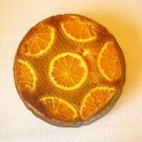 orange olive oil cake with orange slices on the top.