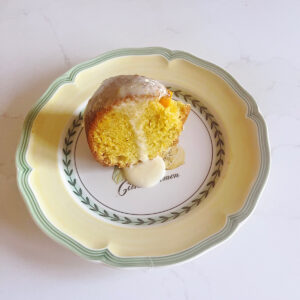 a slice of orange olive oil cake drizzled with orange glaze on a plate.