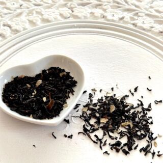 Black currant looseleaf tea in a white heart shaped dish.