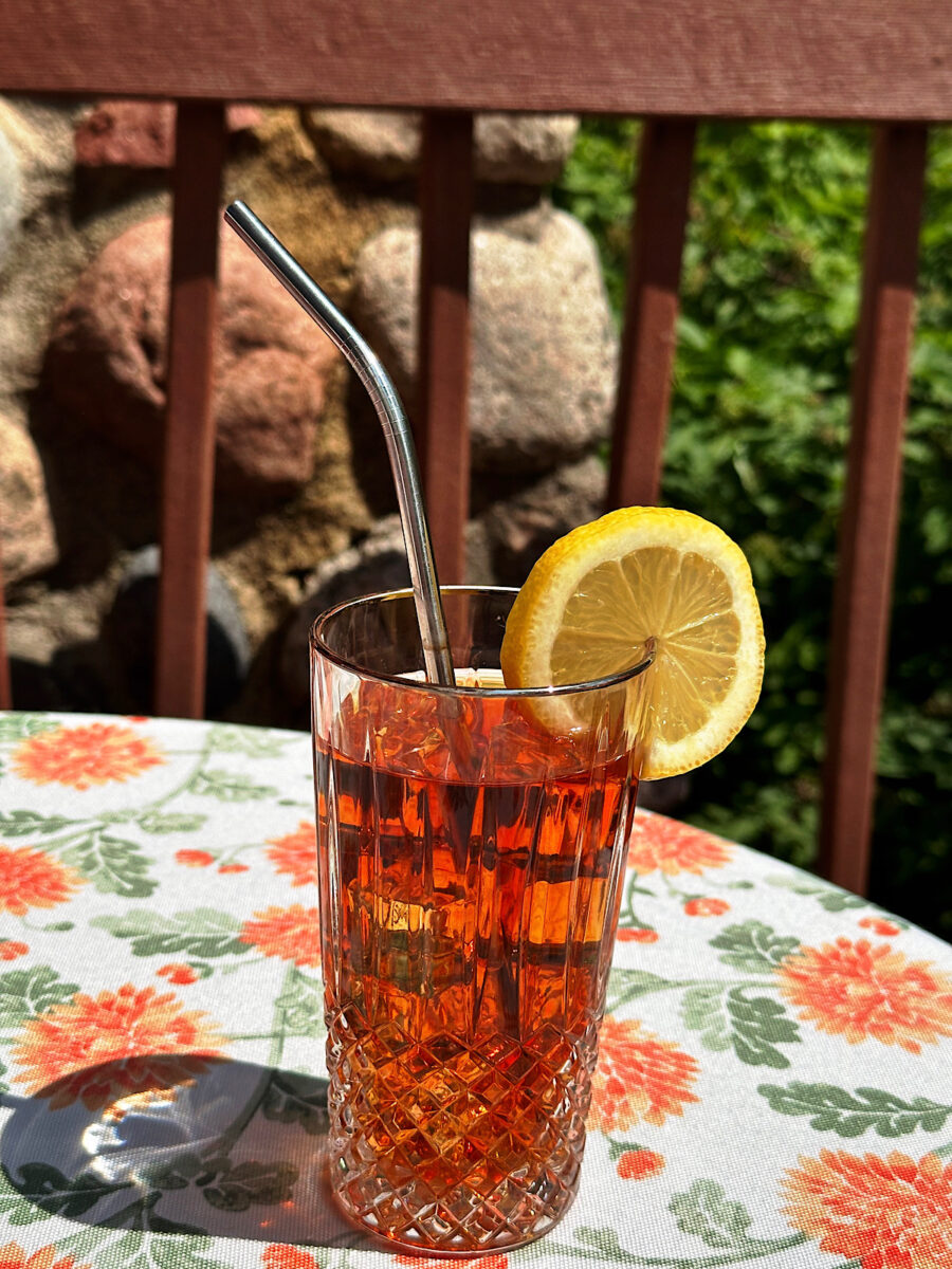 Paradise Red iced tea in glass with metal straw.