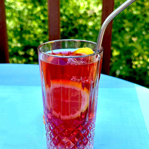 Fruit blend iced tea in glass with metal straw from HeathGlen Farm.