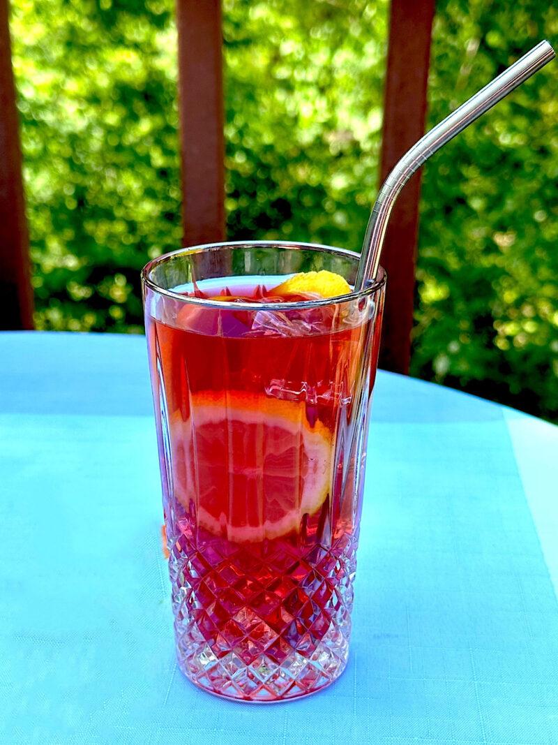 Fruit blend iced tea in glass with metal straw from HeathGlen Farm.