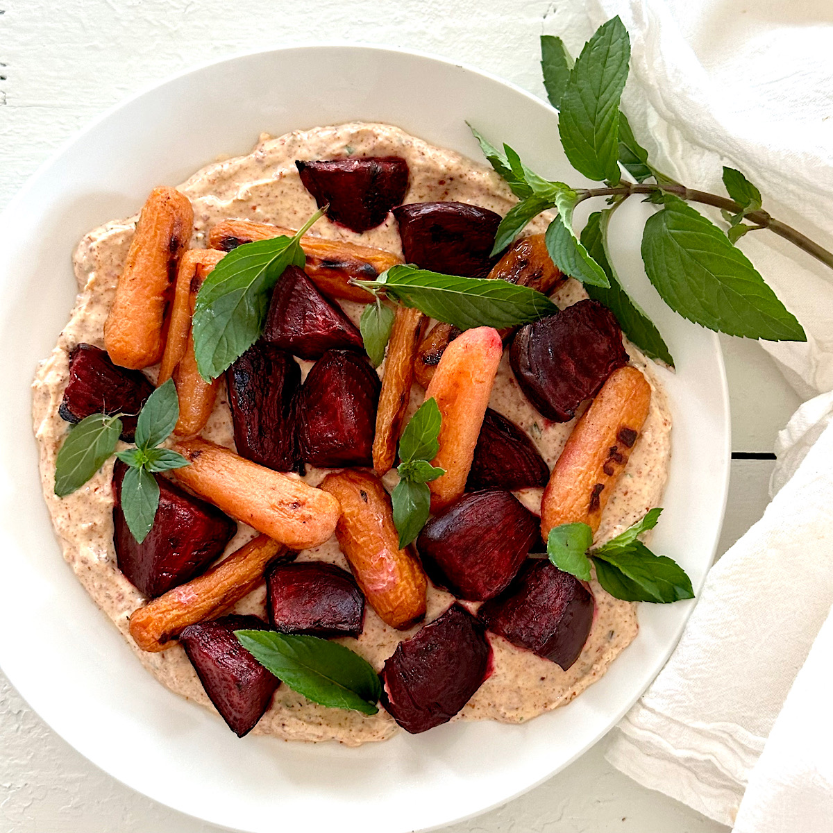 Red beets and carrots on seasoned yogurt puree with mint.