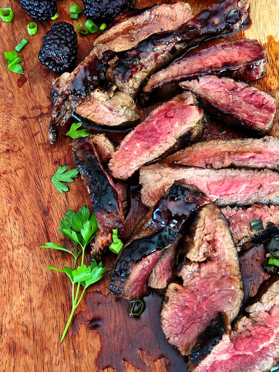 Sliced Flank steak with blackberry glaze on cutting board