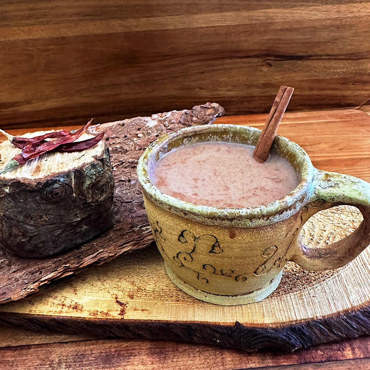 Cup of champurrado with cinnamon stick.