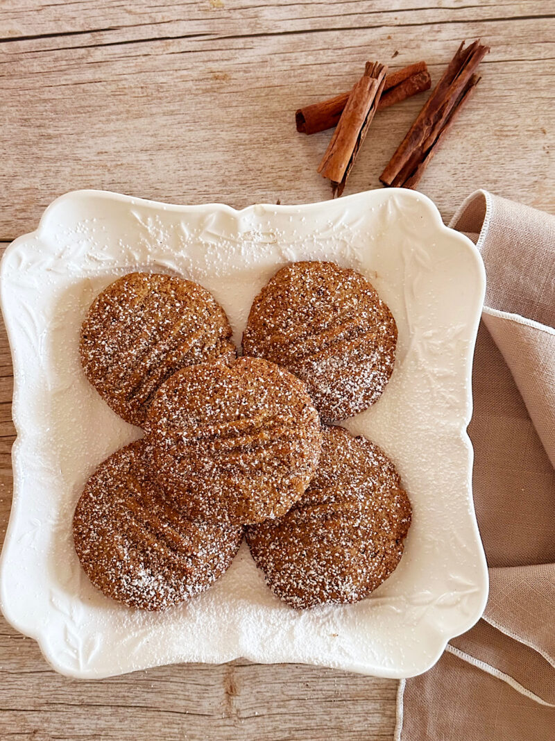 Mexican spice cookies with cinnamon sticks in background.
