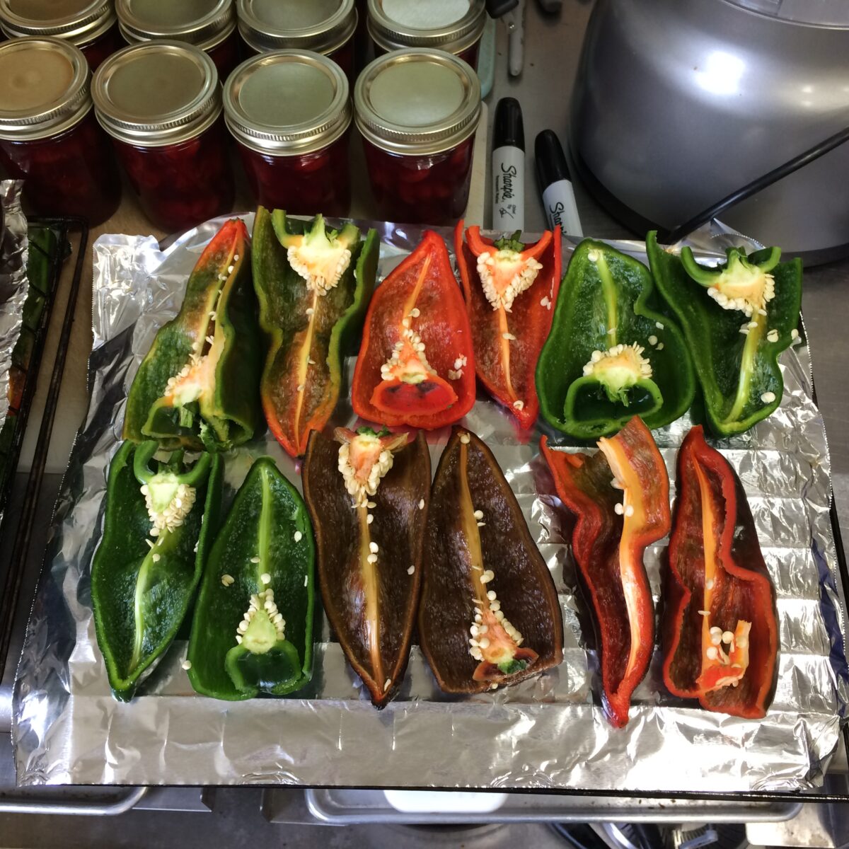 Poblano peppers on a pan covered with foil ready for roasting.