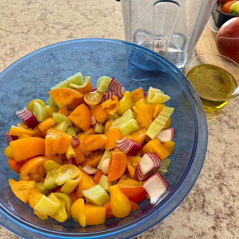 Large bowl of yellow gazpacho ingredients from HeathGlen Farm, resting before being blended with oil.