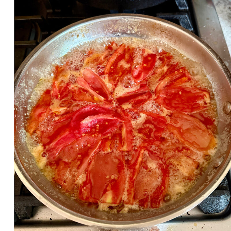 Roma tomatoes cooking in butter and sugar to caramelized for a tomato tarte tatin.