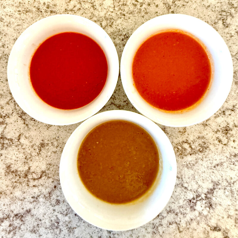 Three different heirloom tomato sauces, top left is with red heirloom tomatoes, top right is with orange heirloom tomatoes and bottom center is with green heirloom tomatoes